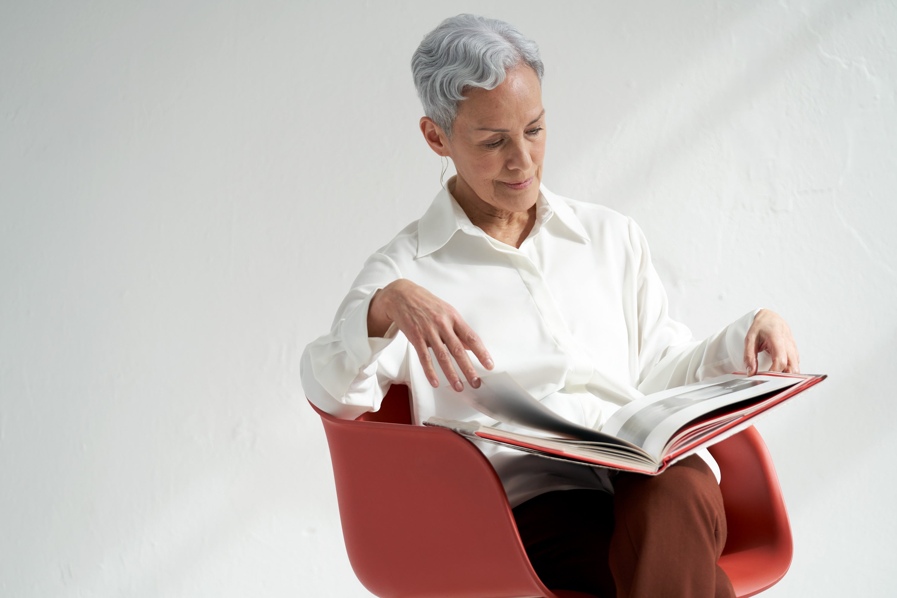 Ältere Frau mit Bluse - ein Buch lesend