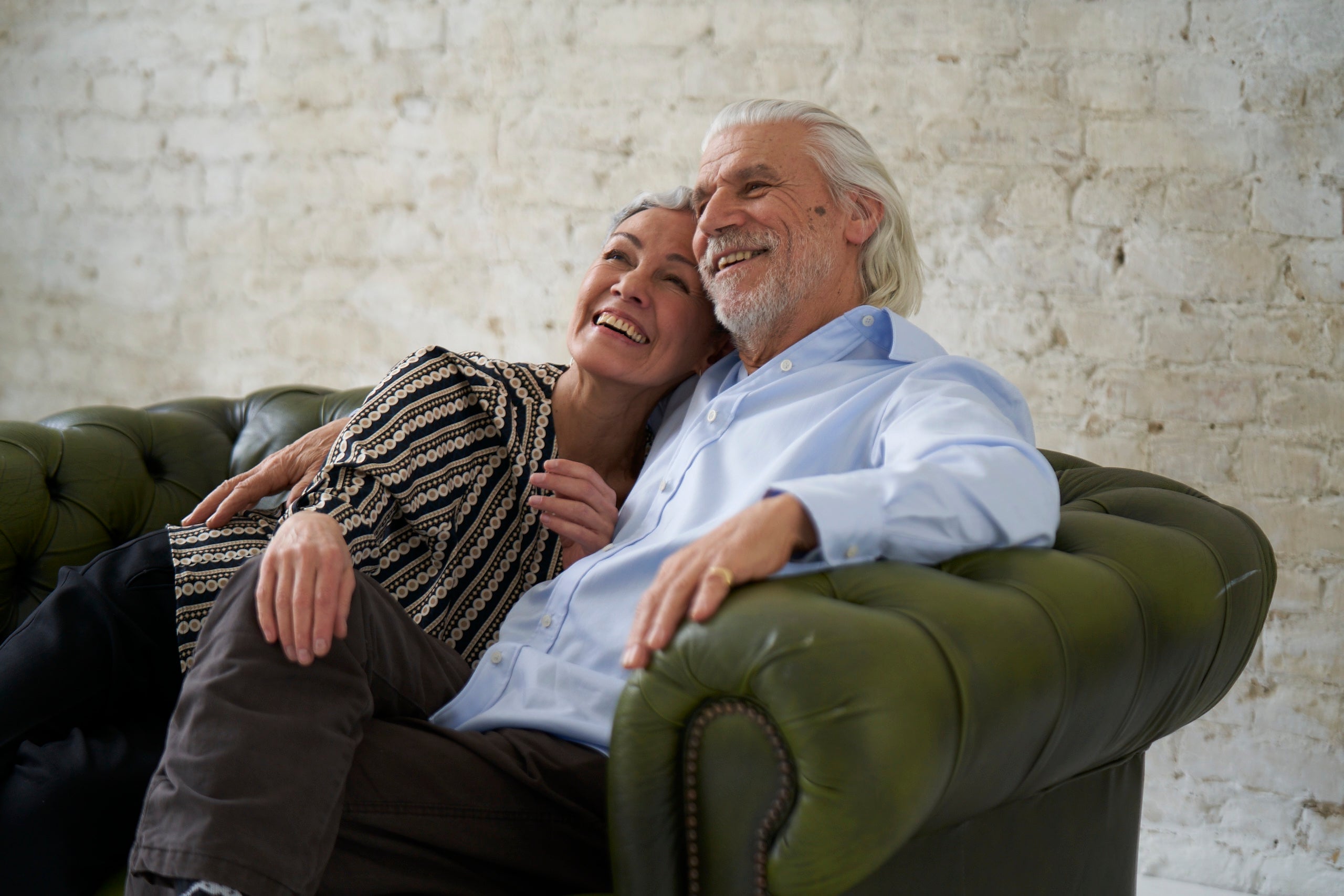Senior Man and woman sitting on sofa wearing Iris & Fred clothing